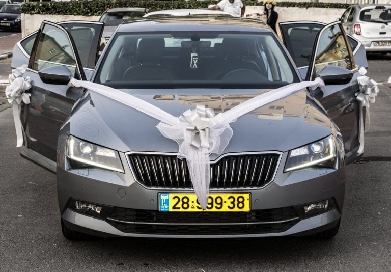 קישוט רכב חתונה – סרט V לבן, פפיון מרכזי ודלתות פתוחות עם פפיונים, עיצוב רכב חתן ברחובות