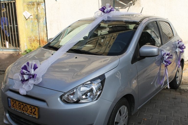 קישוט רכב עם סרט טול לבן ופפיונים סגולים – עיצוב רכב כלה ברחובות